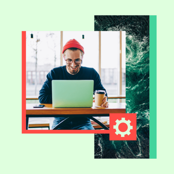 Man in hat types on a laptop.